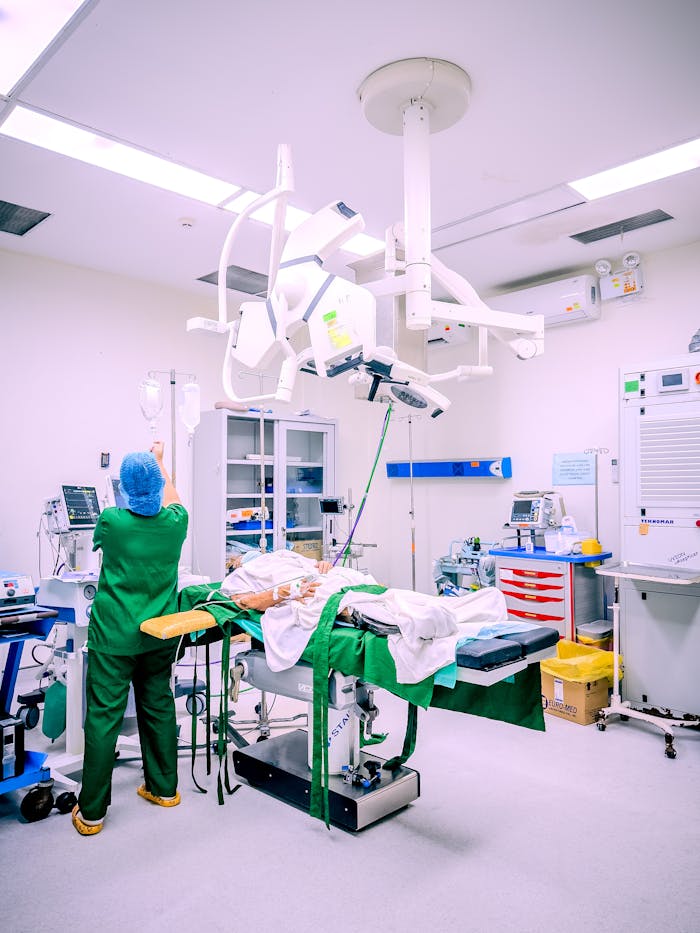 our-experience A nurse in a Central Visayas hospital operating room setting adjusting IV equipment during surgery.